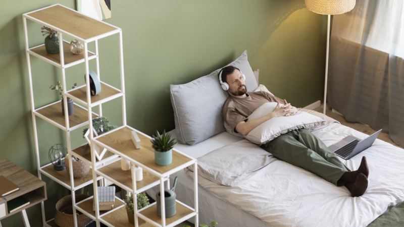 Мужчина лежит в комнате, разделенной с помощью мебели