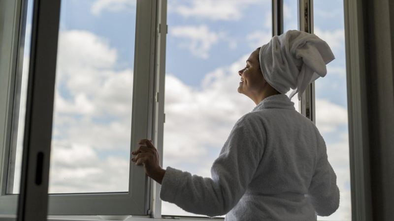 Девушка смотрит в окно, оценивая плюсы и минусы разных этажей